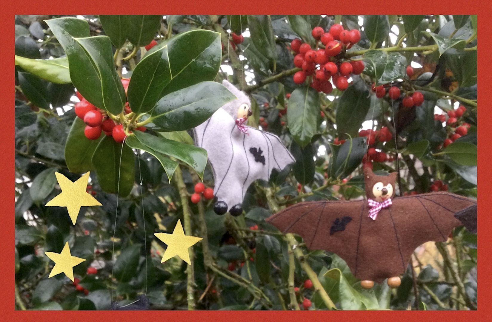 Weihnachtsmotiv Stechpalmenblätter mit roten Beeren 2 Fledermauspuppen und Sternen